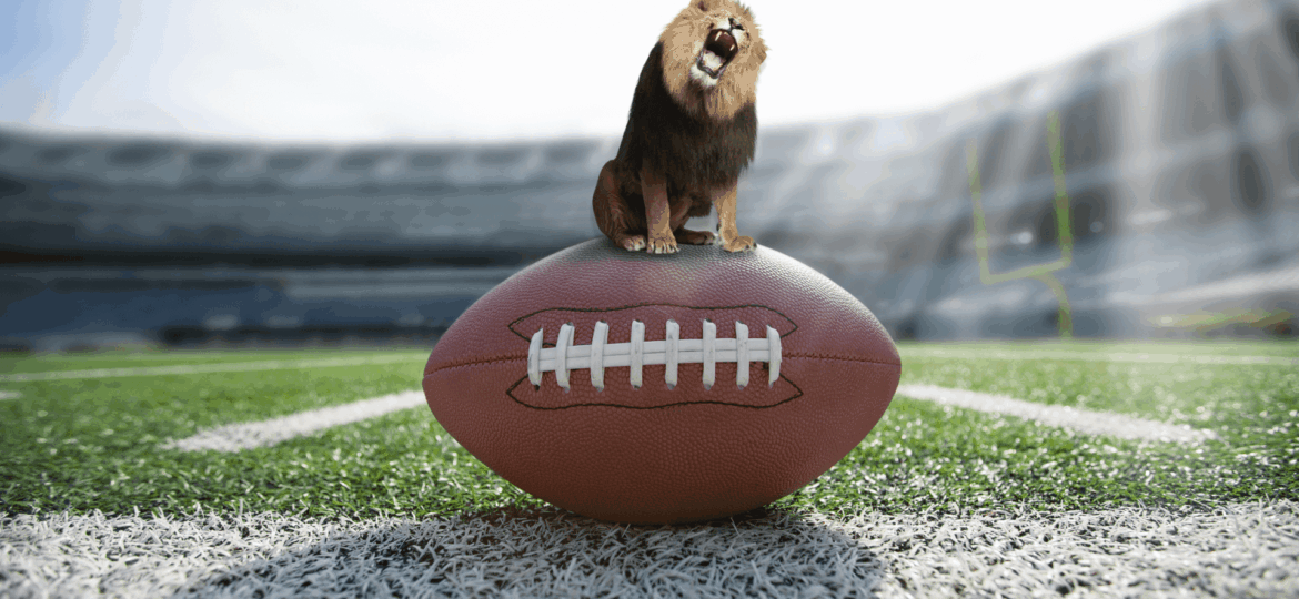 A roaring lion standing on a football in a football field