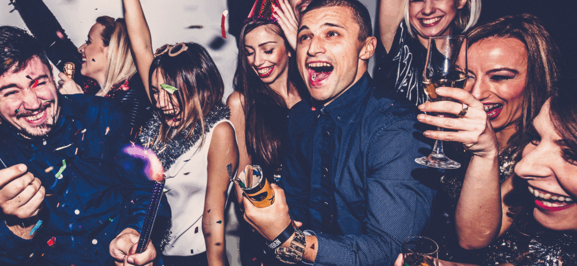 Group of friends celebrating with drinks and confetti on a Detroit party bus, enjoying a fun and memorable night with Dream Limousines Detroit.