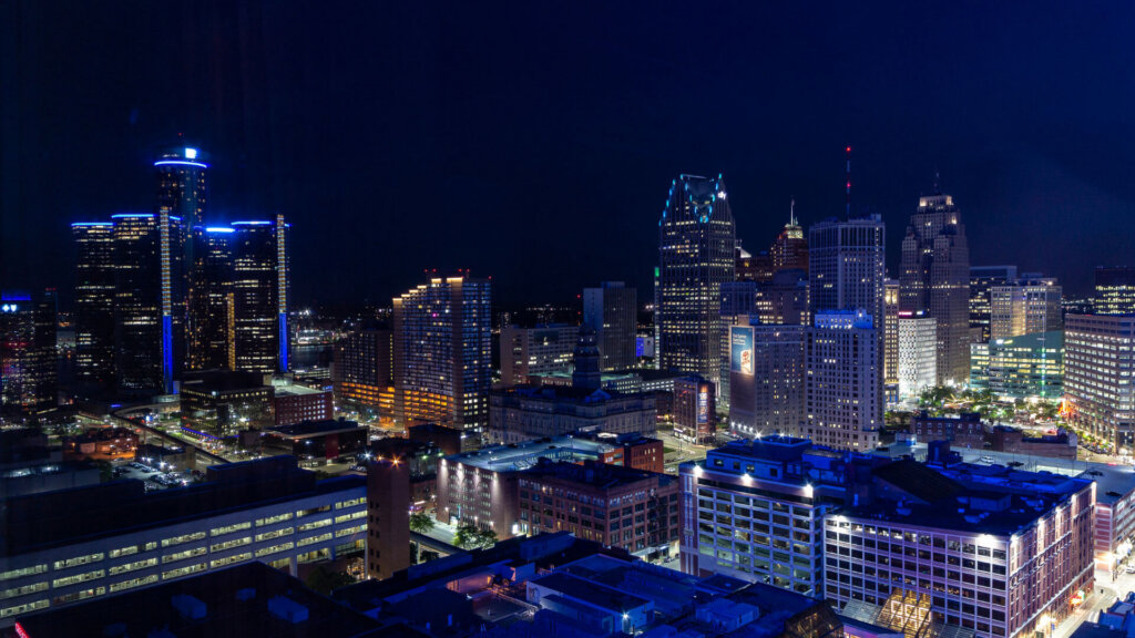Downtown-Detroit-skyline-at-night-showcasing-city-lights-and-illuminated-high-rise-buildings-and-office-towers-against-a-dark-sky